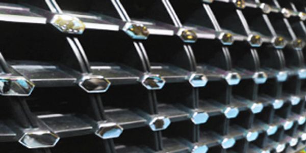 Close-up of a car grille with hexagonal chrome elements achieved through exterior hot stamping foil.