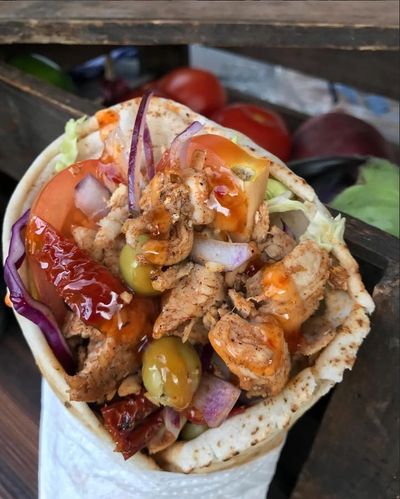 Close-up of a delicious chicken wrap with vegetables and sauce.