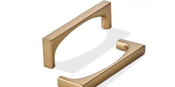 Two sleek, gold-colored modern handles on a white background.