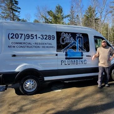 Plumbing service van with contact info and a worker standing beside it.