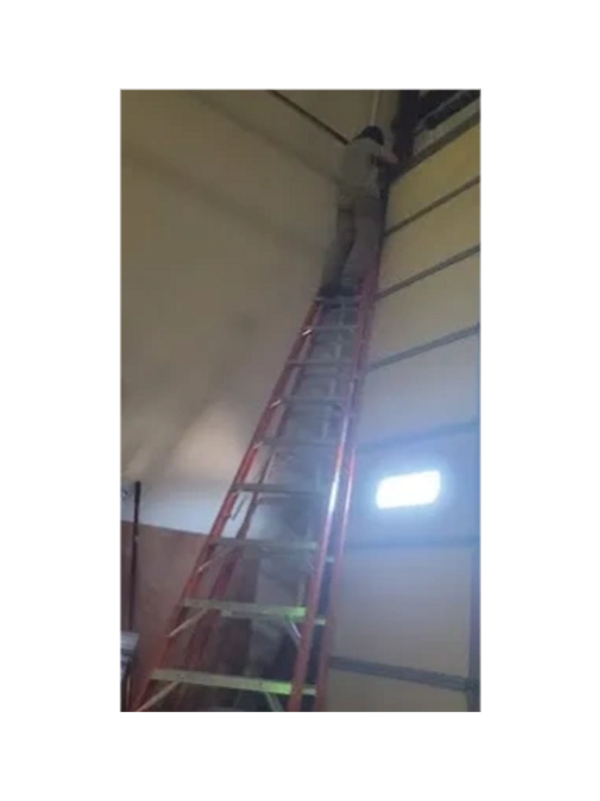 Same Day Garage Door Repair's Commercial Techs, adjusting torsion springs tension on a 14' door.