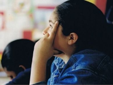 A young student contemplates what to write.