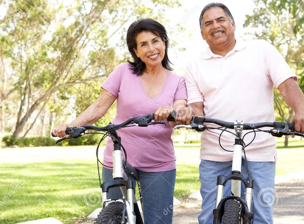 A couple riding their bikes in an open park