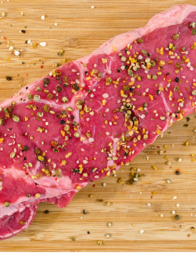 A picture of a meat with sprinkled spices on it