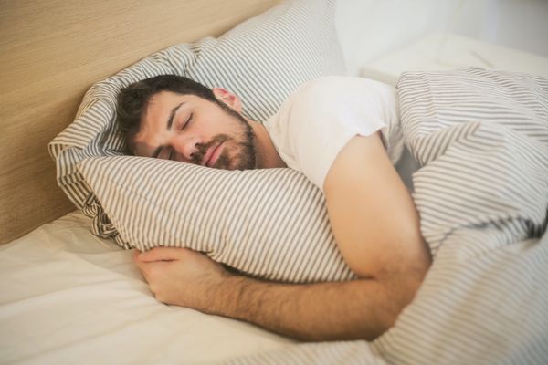 A sleeping person on his bed while holding bed