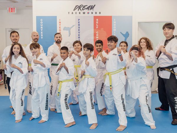 Group of diverse taekwondo students posing in fighting stances at a martial arts studio.