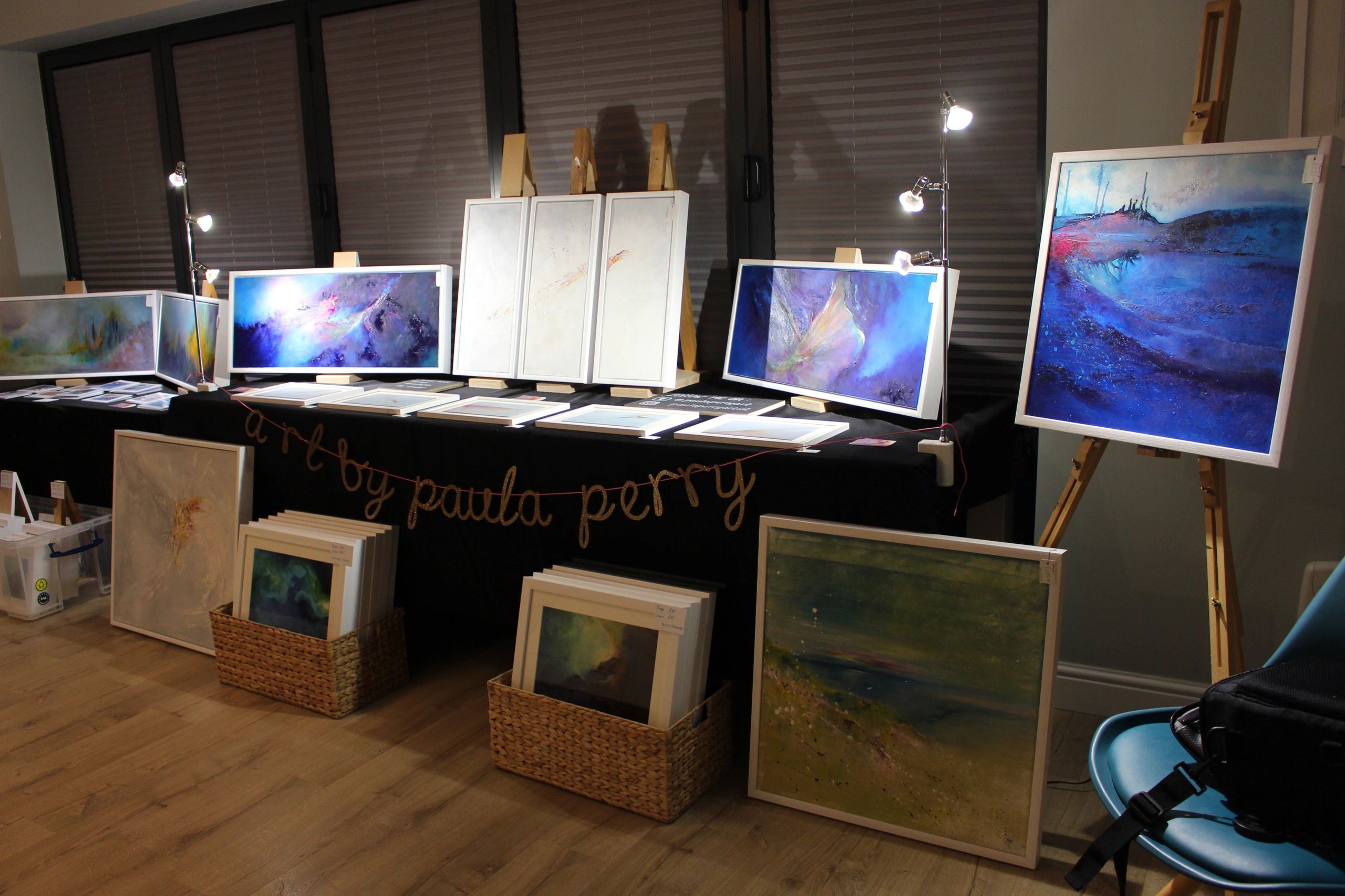 Bold paintings laid out on a table for an art party at a client's home