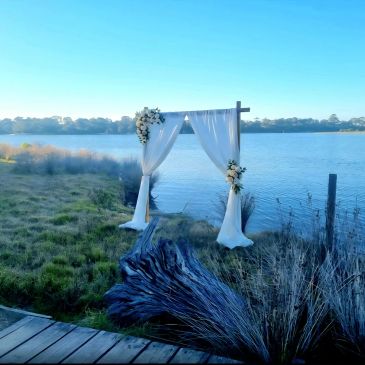 Decorated wedding arch by a lakeside.