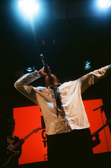 Singer passionately performing on stage under bright lights.