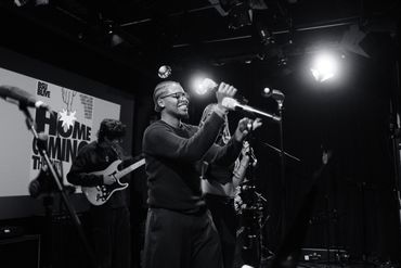 Musicians performing live on stage with guitars and microphones.