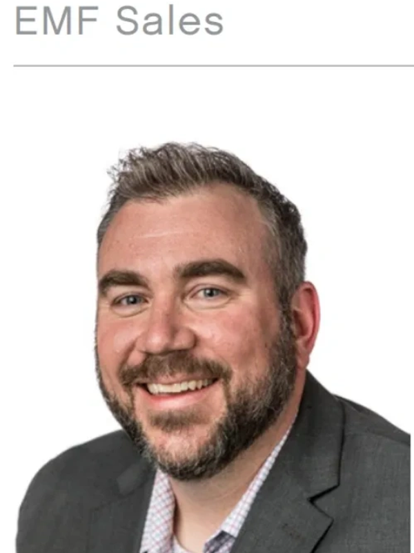 Smiling man in a suit with a beard.
