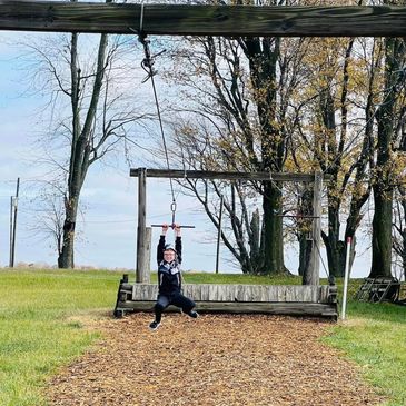 Child enjoying zipline ride outdoors.