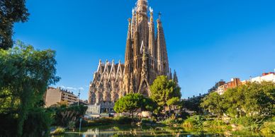 The Sagrada Família basilica in Barcelona under a clear blue sky.