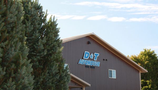 Building with D&amp;T Automotive sign and trees.