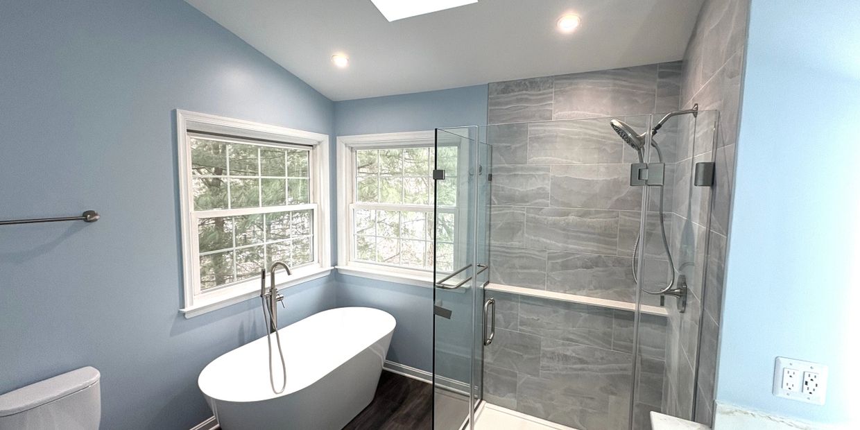 Bright bathroom with a freestanding tub and glass shower enclosure.