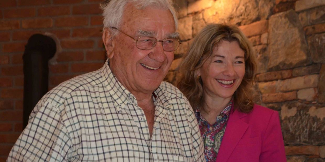 Elderly man and woman smiling indoors.