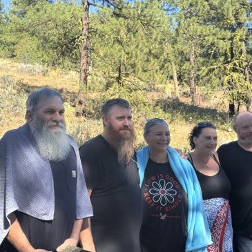 Group of five people standing outdoors on a sunny day.