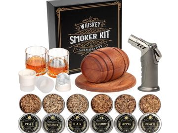 Whiskey smoker kit with wood chips, glasses, and torch.