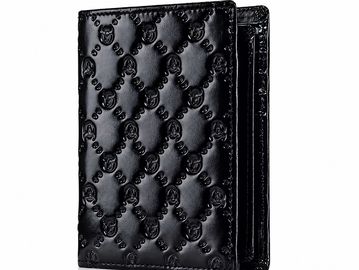 Black Gucci wallet with embossed logo pattern.