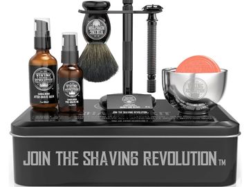 Shaving kit with razors, brush, soap, and aftershave on a black box.