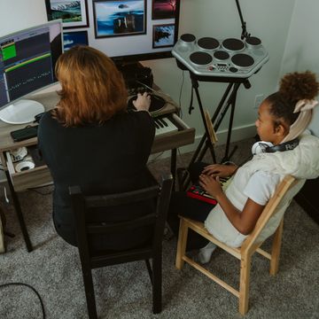 young person and adult teacher working on music production with instruments and computers.