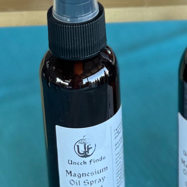 A brown bottle of Uneek Finde Magnesium Oil Spray with a spray nozzle.