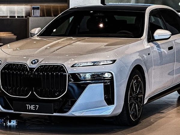 A sleek white BMW 7 Series sedan displayed indoors.