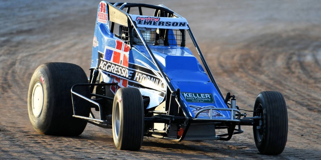 Blue sprint car racing on dirt track.