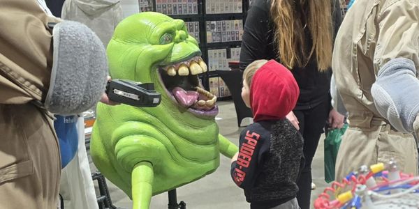 Child interacting with Slimer at a South Dakota Ghostbusters charity event in the Sioux Empire