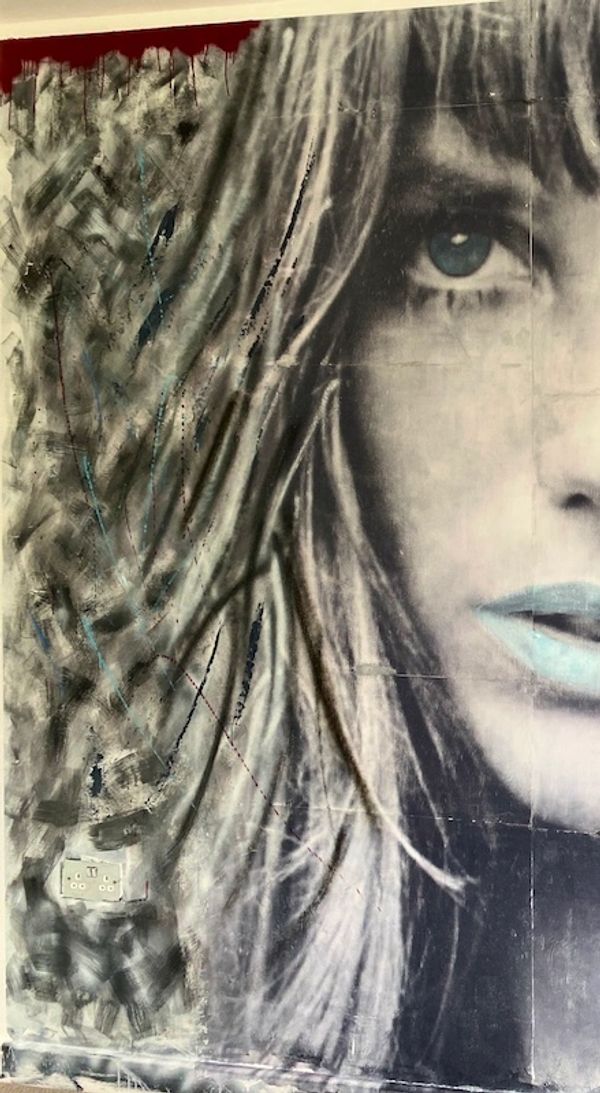 Black and white mural of a woman's face with abstract patterns and a pop of red at the top.