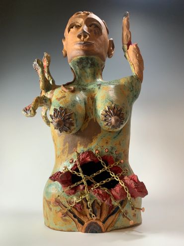 Colorful ceramic sculpture of a woman with chains and flowers.
