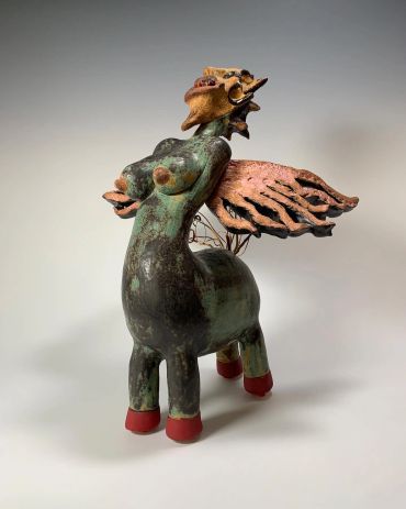 Whimsical winged centaur sculpture with a playful expression.