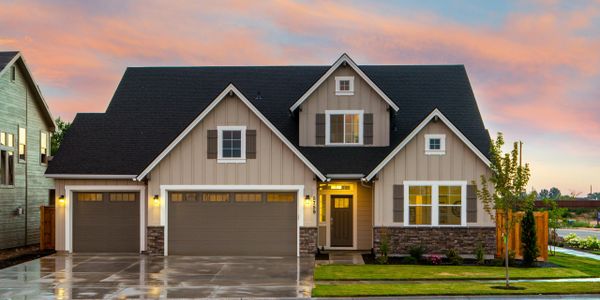 Modern suburban house with a three-car garage at sunset.