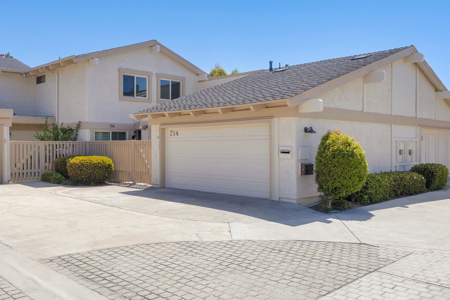 Modern townhouse with gated patio and garage.