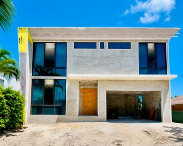 Unfinished modern concrete house with large windows.