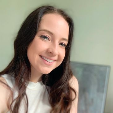 Young woman smiling with long brown hair.