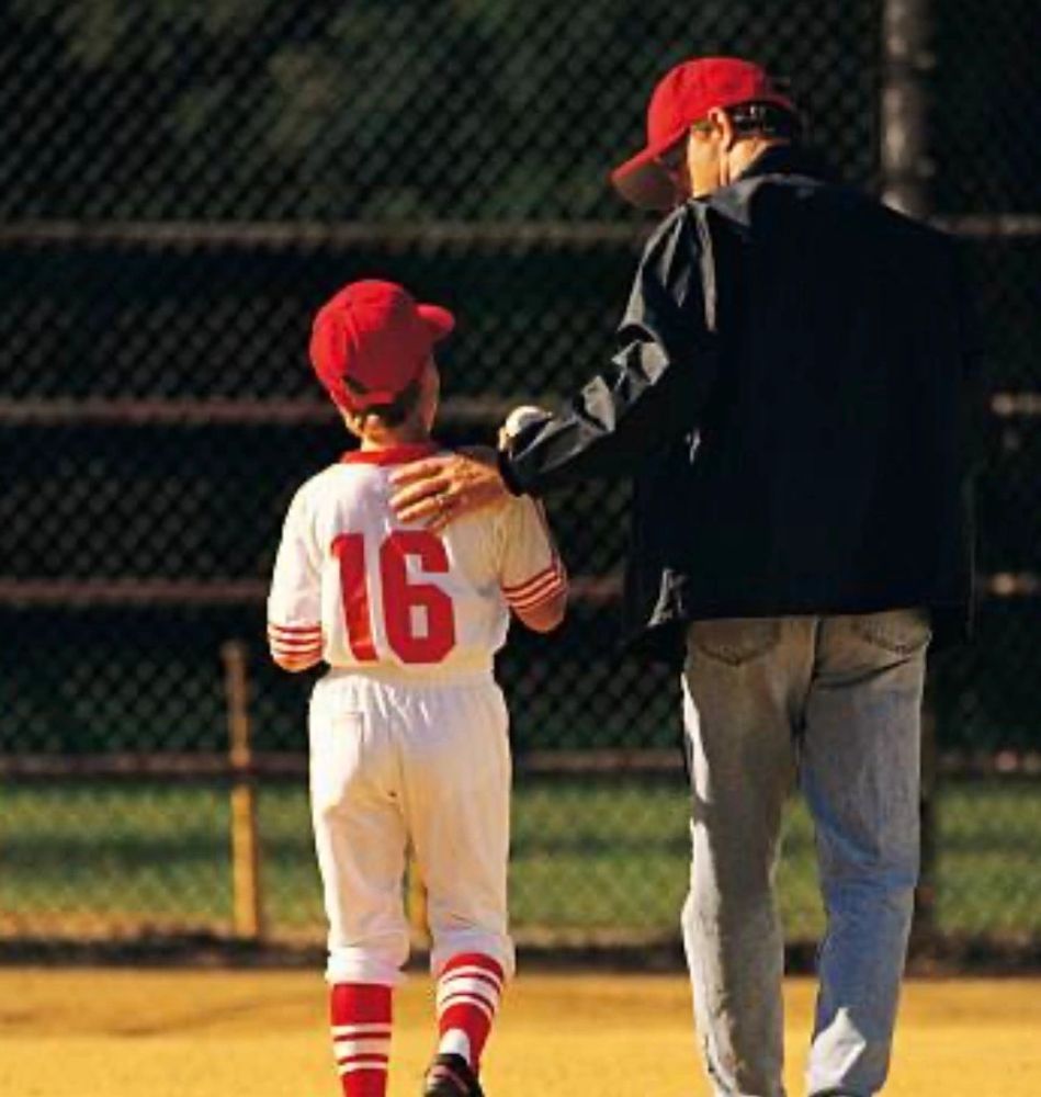 Coach encouraging young baseball player during practice.