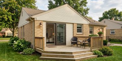 Cozy backyard deck with seating attached to a single-story brick house.