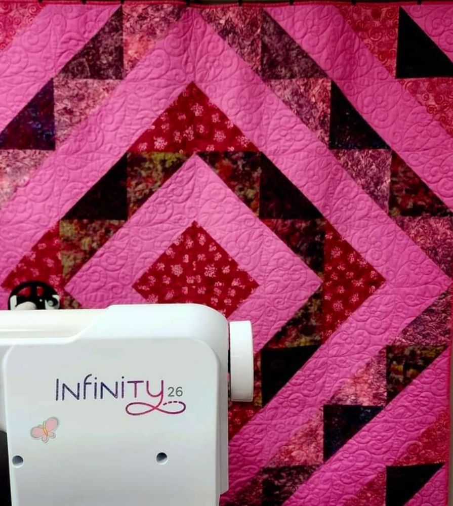 A Doberman rests amidst colorful quilts and vintage sewing machines in a cozy room.