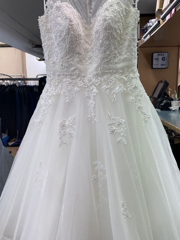 Elegant white wedding dress with intricate lace detailing and tulle skirt.