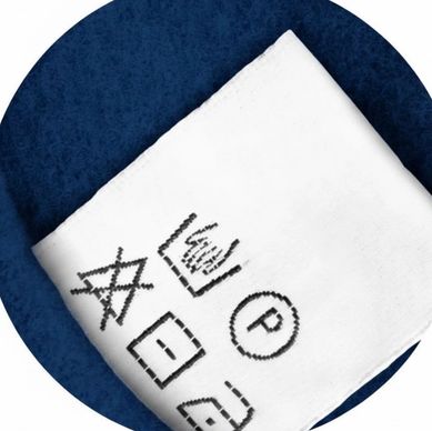 White cloth with black laundry symbols on a blue surface.