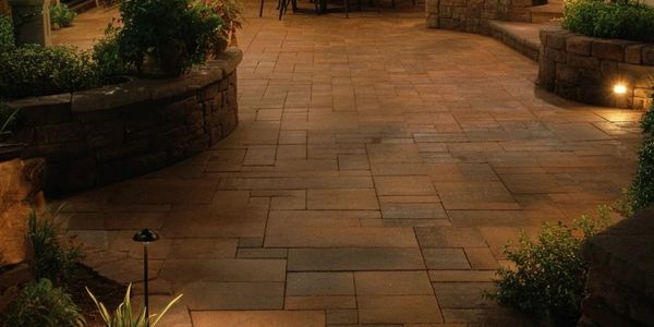Cozy outdoor patio with warm lighting and garden seating at night.
