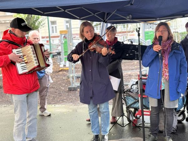 People playing instruments and singing under a canopy.