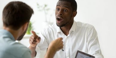 a man talking to another man with a finger pointing towards him
