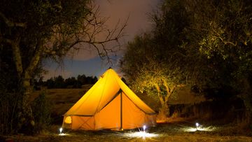 Bell tent at dusk with lights