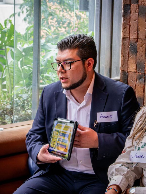Man named Leonardo presenting something on a tablet in a meeting.