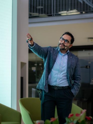 Hombre dando una presentación con micrófono y puntero.