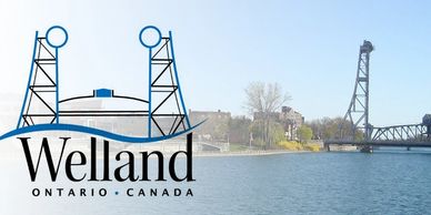 View of Welland, Ontario with water and a bridge tower under a clear sky.