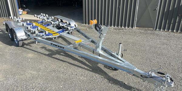 Metal trailer with rollers for transporting boats.