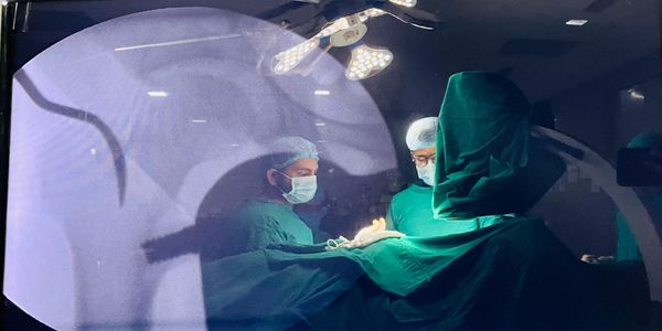 Surgeons performing a delicate operation under bright surgical lights.